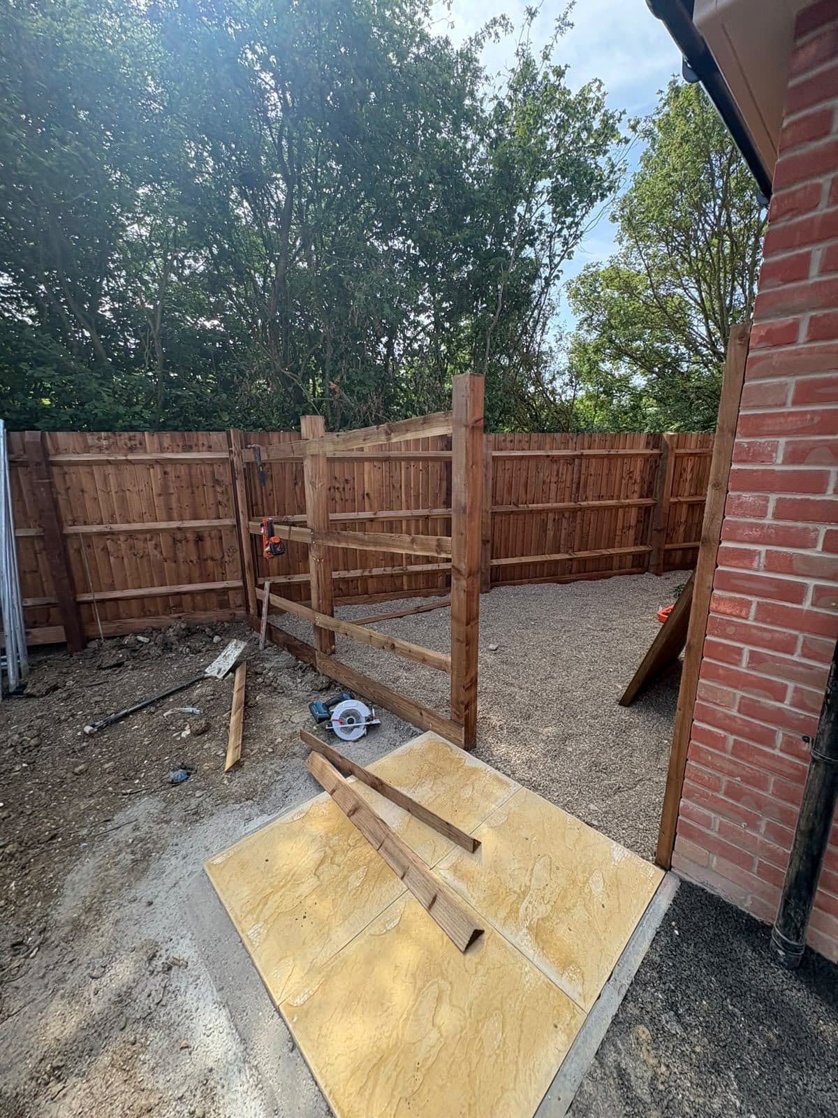 New fence and gate being built beside a gravel area