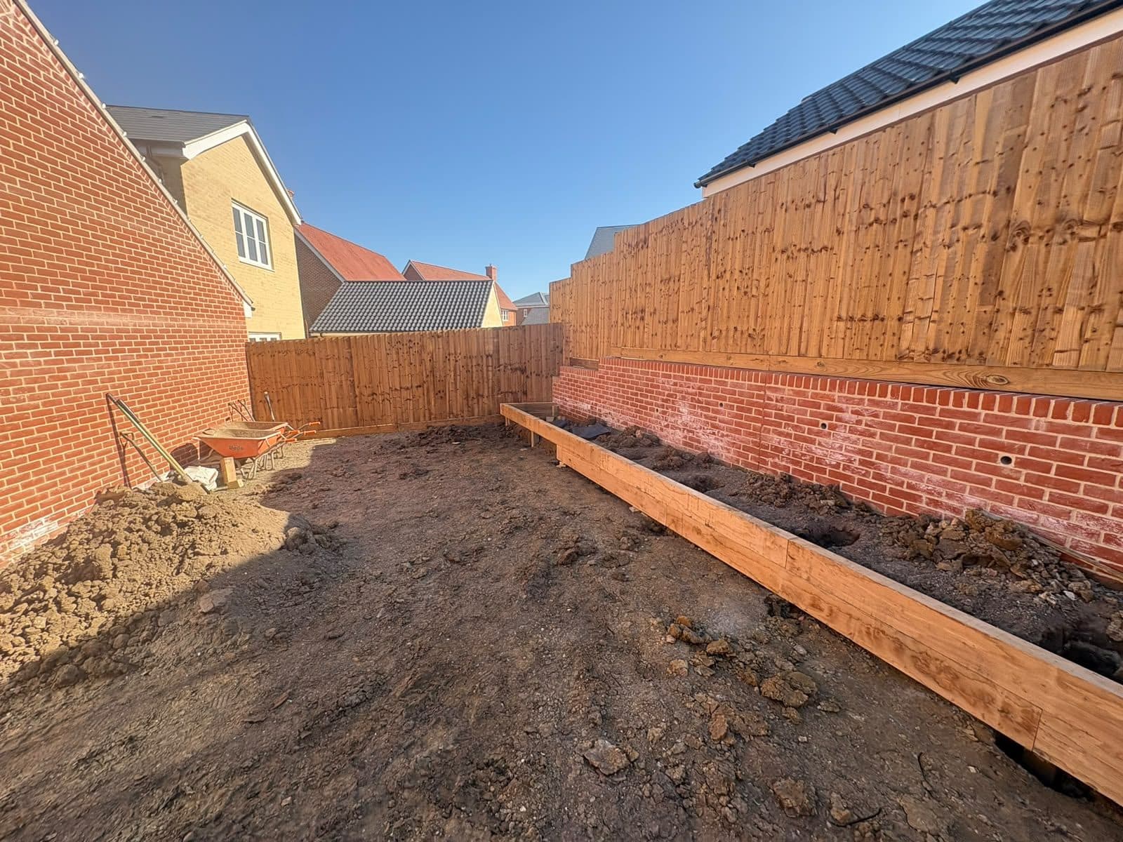 Brick retaining wall with an oak sleeper bed along its base