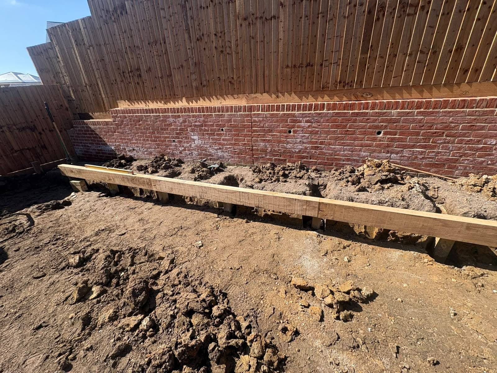 Close-up of a brick retaining wall with oak sleeper edging