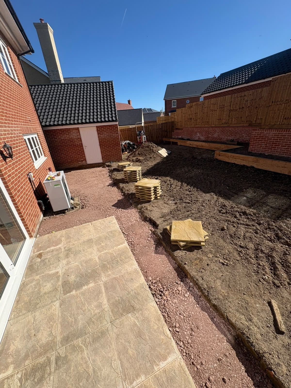 Paving slabs stacked on a prepared sub-base, ready to lay