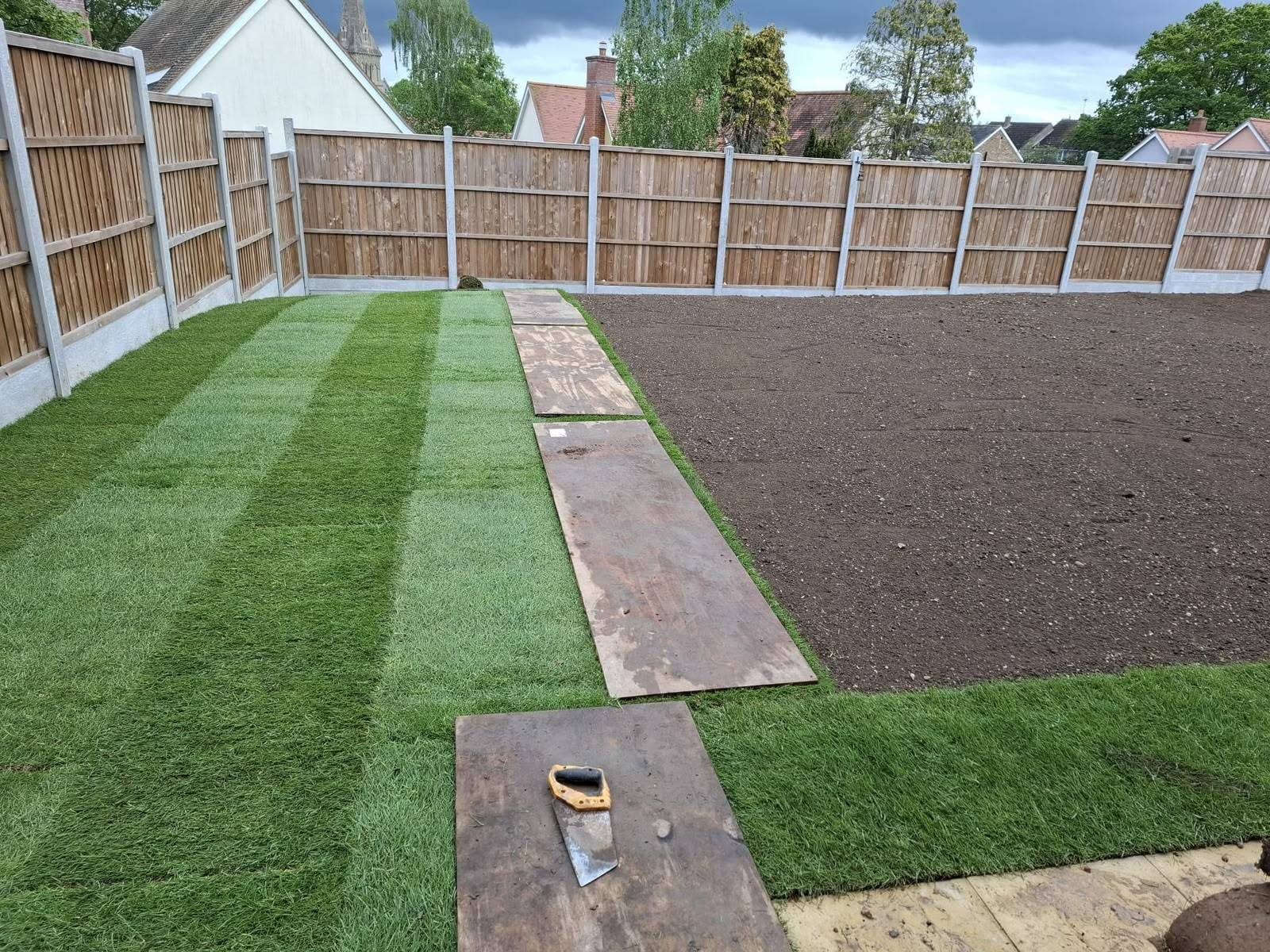 New turf being laid over a levelled soil base