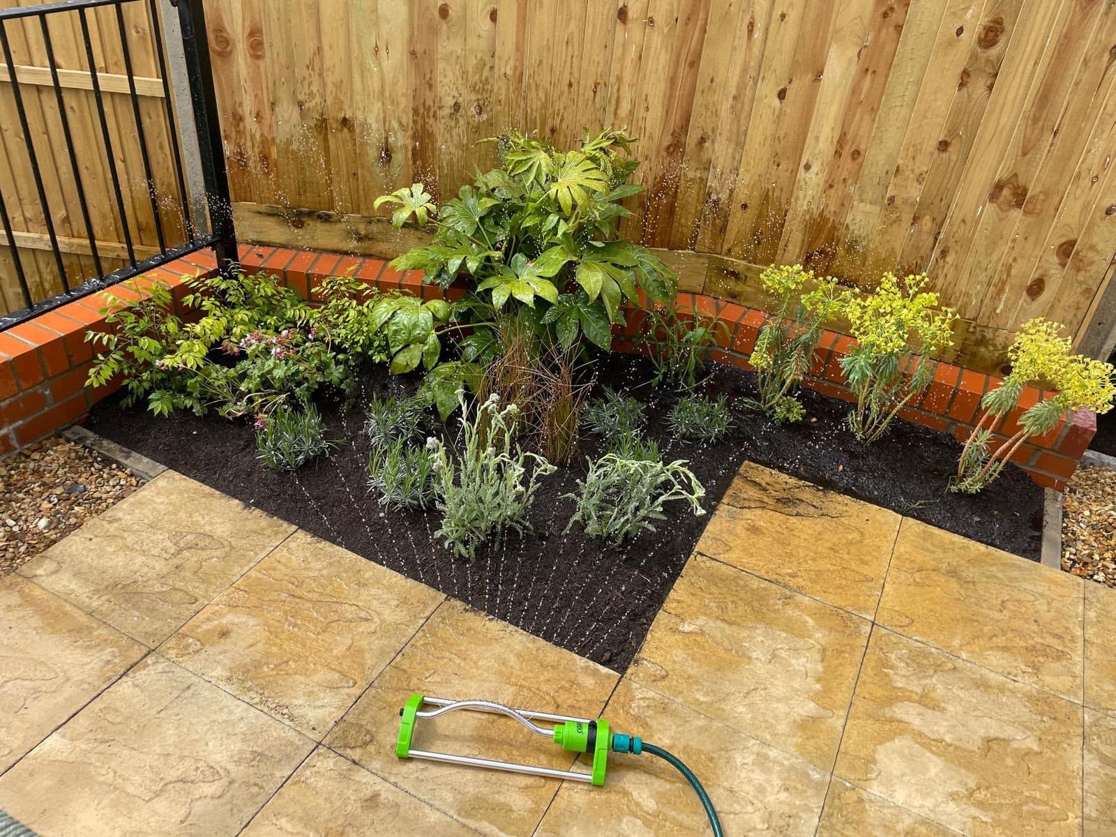 Curved brick planter wall around a corner bed